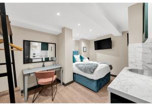 伦敦Experience Local: Quaint Studio in Cental Location的配有一张床和一张书桌的酒店客房