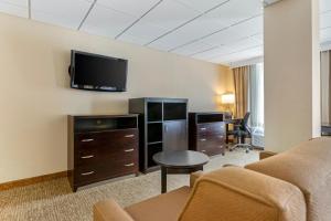 Triadelphia康福特茵套房酒店的酒店客房设有一张沙发和一台墙上的电视。