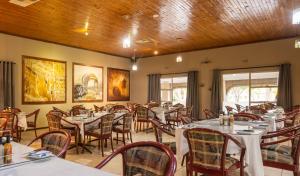 库鲁曼Kuruman Lodge的一间在房间内配有桌椅的餐厅