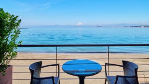叶山町选择套房酒店的俯瞰大海的阳台配有桌椅