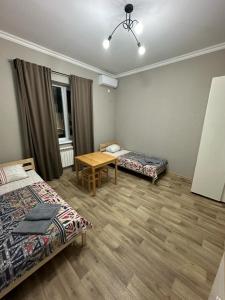 阿克套Гостевой Отель-125的一间设有两张床和一张桌子的房间