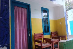普拉亚OYO 93359 Kawi Homestay的一间设有两把椅子和五颜六色的门的房间
