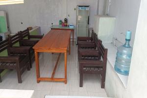 普拉亚OYO 93359 Kawi Homestay的配有桌椅和花瓶的房间