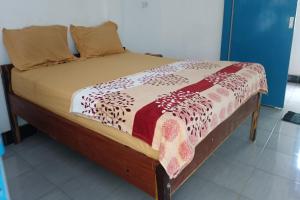 普拉亚OYO 93359 Kawi Homestay的一张木架床,上面有毯子