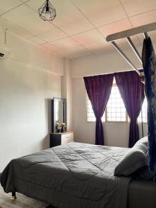 加影Homestay Vista3A at Vista Seri Putra的一间卧室配有一张大床和紫色窗帘