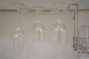 首尔Soo Guest House的四杯玻璃酒杯挂在墙上