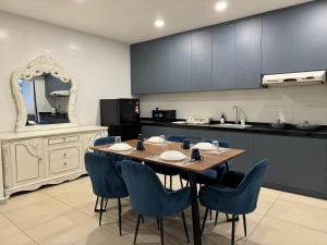吉隆坡Reizz Residence by Perkasa的厨房配有木桌和蓝色椅子