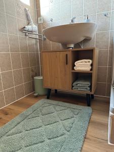 托特瑙Bollenlodge - Ferienwohnung mit Ausblick und Top Lage的一间带水槽的浴室和一个带毛巾的橱柜