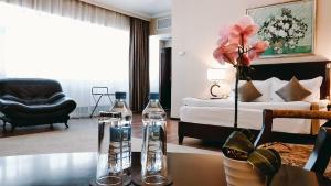 阿斯塔纳REIKARTZ PARK ASTANA ex-Royal Park Hotel & SPA的客厅配有床和一张桌子及两瓶