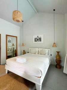 沙拉海滩Tropical Crystal Villa的白色的卧室配有白色的床和镜子