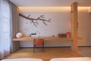 上海上海光时旅行酒店的墙上有枝条的房间里一张桌子