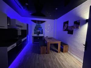 盖尔森基兴Wellness Suite mit Whirlpool und Sauna的紫色客房,厨房配有桌子