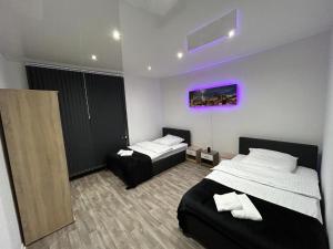 盖尔森基兴Wellness Suite mit Whirlpool und Sauna的一间卧室设有两张床,墙上挂着紫色的画作
