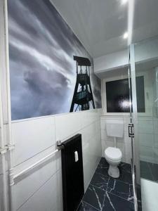 盖尔森基兴Wellness Suite mit Whirlpool und Sauna的一间带卫生间的浴室和墙上的绘画