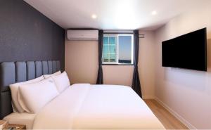 浦项Hotel Daon的一间卧室配有一张床和一台平面电视
