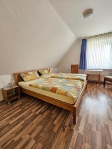 诺德奈Ferienhaus Wellsandt的一间卧室设有一张大床,铺有木地板。