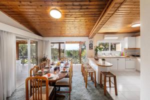 普拉特斯Platres Forest Panorama Cottage的厨房以及带长桌和椅子的用餐室