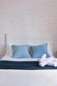 马拉加Larios Premium Apartments的白色的床和蓝色的白色枕头
