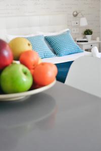 马拉加Larios Premium Apartments的睡床旁的桌子上放一碗水果