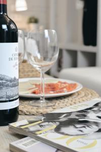 马拉加Larios Premium Apartments的一张桌子,上面放着一瓶葡萄酒和一盘食物