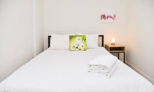 门德里西奥Modern apartment Dora的白色的床、白色床单和黄色枕头