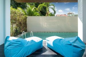 卡塔海滩3-Story Pool Villa Katahan UTK B4 just 7 min walk to Kata Beach的游泳池旁设有两张充气床
