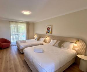 巴瑟尔顿The Timothée Resort的酒店客房,配有两张床和椅子