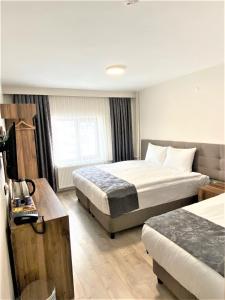ErciyesZümrüt Palas Otel的酒店客房配有两张床和一张书桌