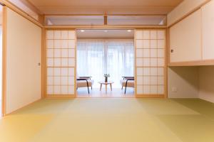 箱根Stagione Hakone Yumoto Villa スタジオーネ箱根湯本VILLA的一间拥有白色墙壁和桌椅的房间