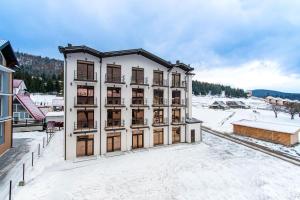 布克维GARDA - Breakfast included in the price Restaurant Free Parking Mountain view Kitchen in the apartment separate entrance的雪中建筑物的空中景观