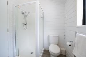 HaruruPaihia Coastal 2 Bedroom Cottages的白色的浴室设有卫生间和淋浴。