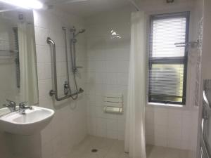 汉默温泉Hanmer Garden Suites的白色的浴室设有水槽和淋浴。