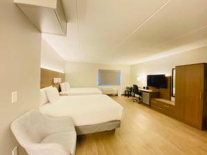 马凯特Superior Stay Hotel的酒店客房设有一张床、一张书桌和一台电视机。