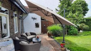 GuelleB&B de Maaskei的庭院里设有带椅子和遮阳伞的庭院。