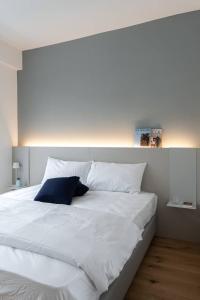 特伦托Casa Kaleido的一张白色的大床,上面有蓝色的枕头