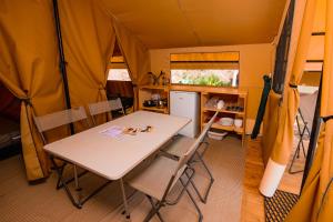瓦瑟洛讷Camping Onlycamp de Wasselonne的帐篷内的用餐室配有桌椅