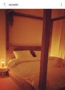 Al RahbaMy Resort的一间卧室配有一张木架大床