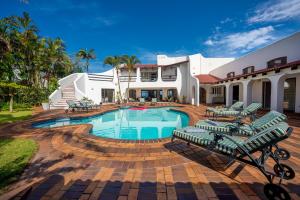 巴利托Lalaria Ocean Villa Suite 3的一座房子,里面设有游泳池、椅子和一座房子
