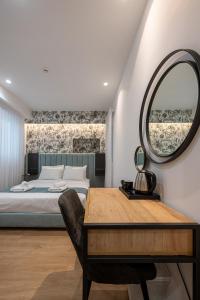 雅典Kriel Suites by LIV Homes的一间卧室配有一张床、镜子和一张桌子