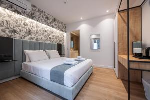 雅典Kriel Suites by LIV Homes的一间卧室配有一张大床和电视
