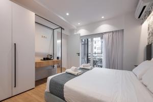 雅典Kriel Suites by LIV Homes的白色的卧室设有一张大床和一个窗户