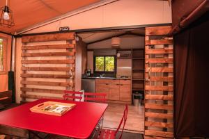 瓦瑟洛讷Camping Onlycamp de Wasselonne的厨房以及带红色桌子的用餐室。