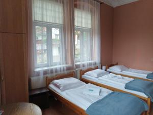 希维拉杜夫-兹德鲁伊Willa Pałacyk的带2扇窗户的客房内的2张床