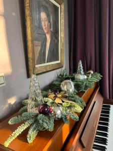 斯帕La Vigie, Spa的钢琴上一幅女画,装饰着圣诞花