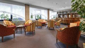 汉堡Hotel Alte Wache的一间设有桌椅的餐厅,位于带窗户的房间内