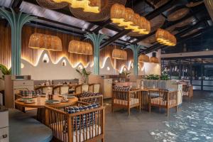 安君纳Moyrah By Greenpark的餐厅设有木桌、椅子和吊灯。