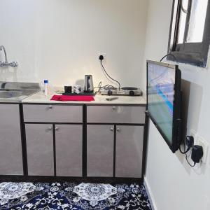 乌姆莱季استديو البركه-Al Baraka Studio的客房设有一个柜台、一张桌子和一台电视