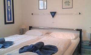 StubbenfeldeKölp - Inselhaus 1的卧室内的两张床,配有蓝色毛巾