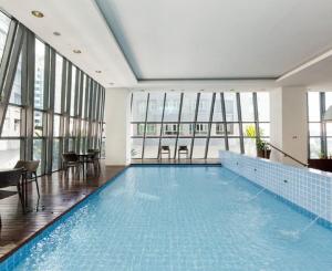 吉隆坡吉隆坡雅诗阁中心酒店的一座大型游泳池,位于一座带窗户的建筑内