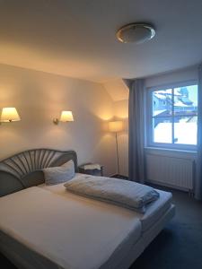 吕登沙伊德Hotel zur Altstadt - Garni的一间卧室设有一张大床和大窗户